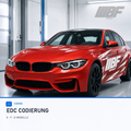 Red F-Series BMW in a bright workshop studio for EDC coding, with Bimmerfit logo and black-and-white side graphics