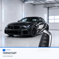 BMW vehicle key in front of a dark vehicle for remote-start activation, with Bimmerfit logo and black-and-white side graphics